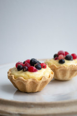 Delicious dessert, tartlets, baskets with sabaione sabaglione cream decorated with berries on white background
