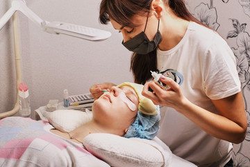 Obraz na płótnie Canvas master eyelash extension at work, apply glue, home workplace