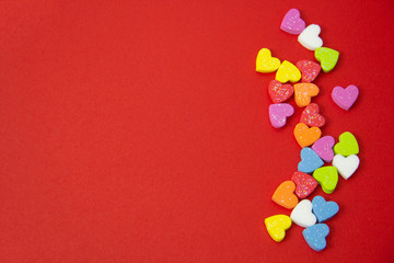 Fototapeta na wymiar A multicolored hearts shape on red background, image using for valentine ‘s day signs and lovely sweet concept