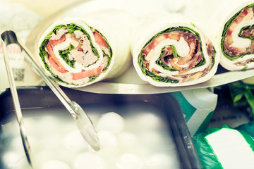 rolls with mozzarella, lettuce, tomatoes, ham and tuna fish on the market in Catania, Sicily, Italy .