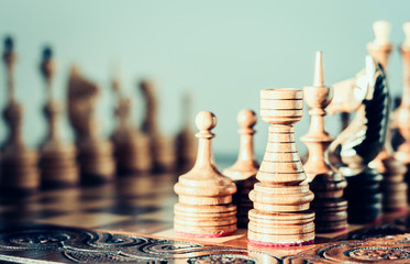 Wooden chess pieces on a chessboard, leadership concept on white background.