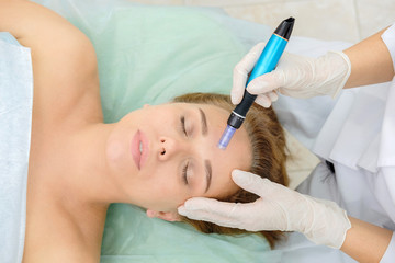 Fototapeta premium Cosmetologist making mesotherapy injection. Microneedle mesotherapy. Treatment woman at beautician. Hardware cosmetology. Mesotherapy, dermapen, treatment of face zone, face rejuvenation. Close up