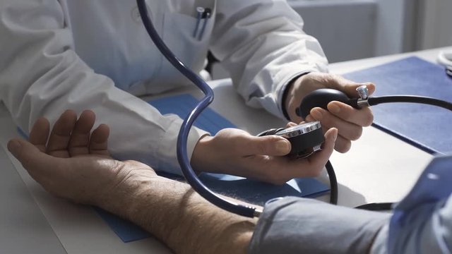 Female doctor measuring blood pressure of a patient