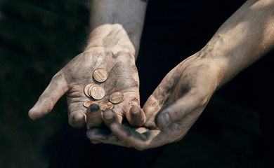 Hand of beggar with some coins begging for money (poverty, hunger, anxiety, bankrupt concept)