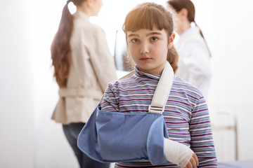 Girl with broken arm and arm brace in the doctor's office