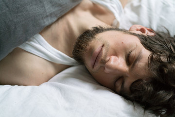 Obraz na płótnie Canvas Cute handsome young man sleeping on bed.
