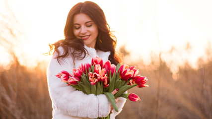 Smiling woman with bunch of flowers