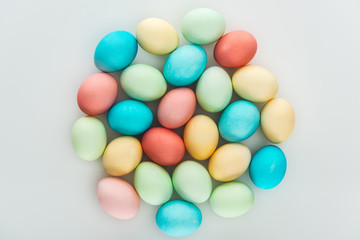 top view of colorful painted easter eggs on grey