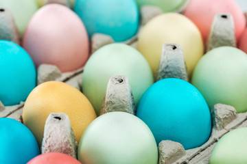 close up of colorful pastel easter eggs in paper containers