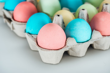 close up of pastel easter eggs in paper containers