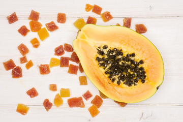 One half lot of slices of dry papaya flatlay on white wood