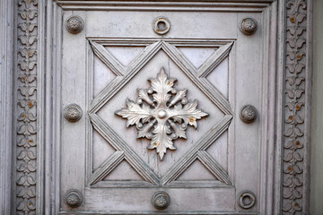 Partial view of an old wooden entrance door of a crypta.