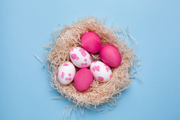 Easter pink eggs with watercolor brushstrokes on a blue background