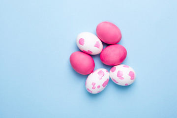 Naklejka na ściany i meble Easter pink eggs with watercolor brushstrokes on a blue background