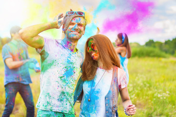 Happy holi party: sunny beautiful women females teenagers and males men in sunglasses celebrating...