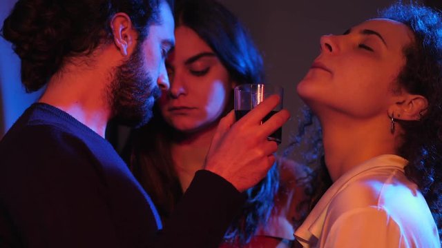 Poligamy,attraction,polyamory. Three people flirting,drinking in night club