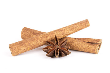 One whole dry brown star anise fruit and two cinnamon sticks isolated on white background