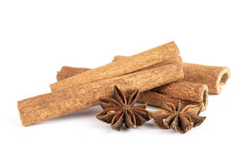 Group of two whole dry brown star anise fruit and three cinnamon sticks isolated on white background