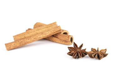 Group of two whole dry brown star anise fruit with three cinnamon sticks isolated on white background