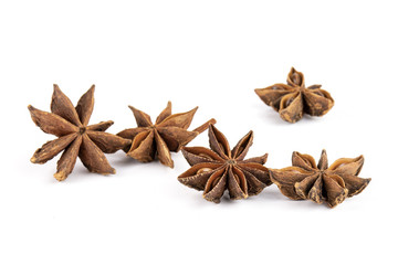 Group of five whole dry brown star anise fruit isolated on white background