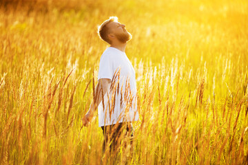 Happy young man stands in the field