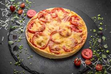 Traditional quiche pie with tomatoes, mozzarella and spinach.