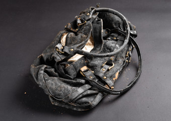 moldy leather bag on dark background