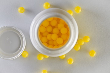 White bottle with yellow pills inside from above