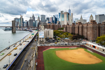 A baseball field along the FDR and East River with views towards the Brooklyn Bridge and Lower Manhattan, New York
