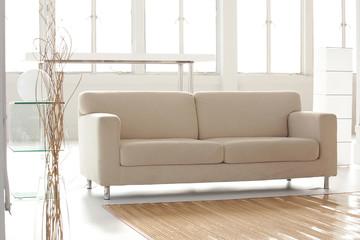 a beige sofa in a withe living room setup