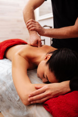Fototapeta na wymiar Male master of SPA center giving professional strong massage