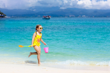 Kids play on tropical beach. Sand and water toy.