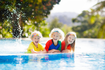 Kids in swimming pool. Children swim. Family fun.