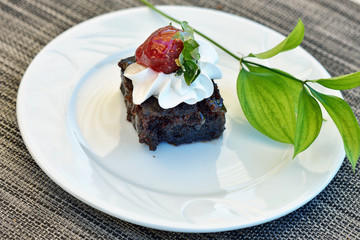 Chocolate cake with strawberry on white plate on table close-up