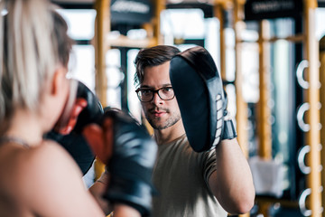 Fototapeta premium Young woman on kickboxing training with her coach.
