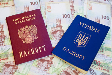 Fototapeta premium Passport of Ukraine and Russia on the background of Russian rubles with the image of the Crimea