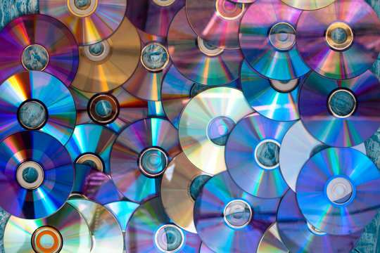 Background on the wall with old damaged discs cd.