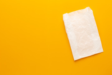White paper bag on yellow background.