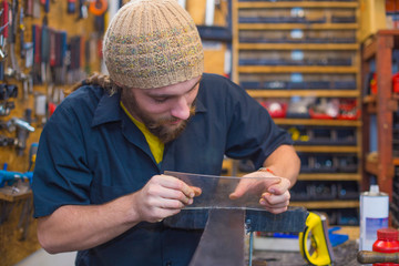 Bearded guy doing handicrafts in the workhop