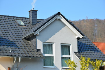 Sattelgaube auf einem Ziegeldach mit Schornstein