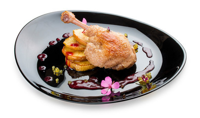 Duck leg with caramelized apple on black glossy plate