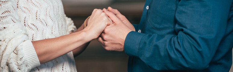 Fototapeta premium cropped view of wife and husband holding hands