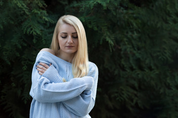 Obraz premium Beautiful young girl, blonde with long hair on the background of green.