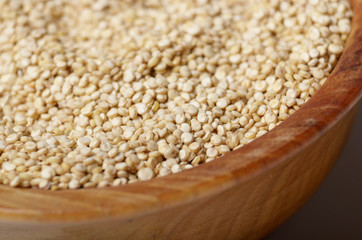 Raw organic superfood gluten free quinoa seeds in wooden bowl closeup