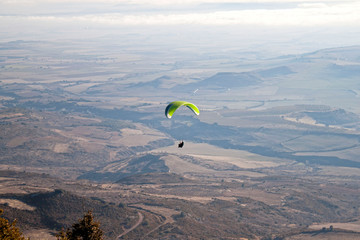 man paragliding in a sunny day over the earth
