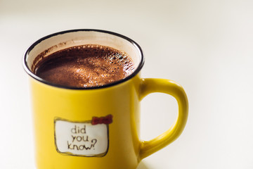 Yellow mug with coffee . With an inscription. Did you know?