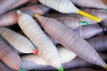 Gray and purple yarn bobbin spools of  cotton thread nature patterns for background