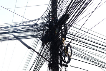 Messy electrical cables and wires on electric pole isolated on white background.