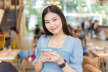 Beautiful women using smartphone internet browser in coffee shop