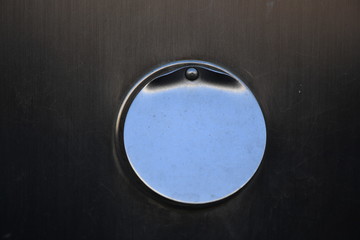 A round chrome plate in the midle of a wall.